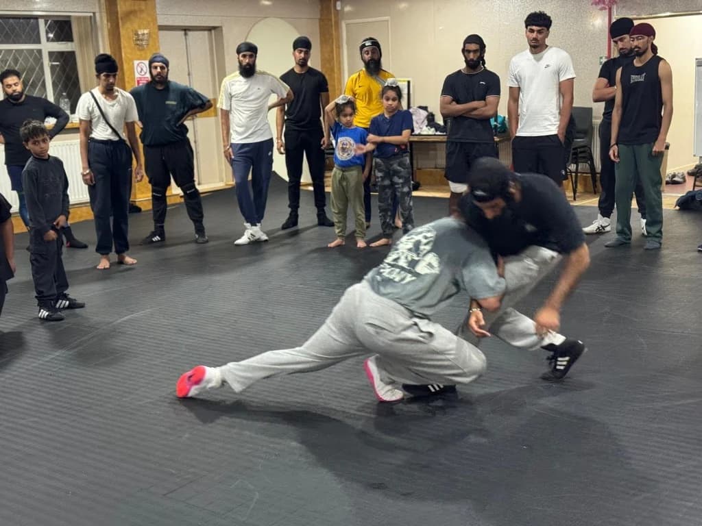 Wrestlers practising a takedown during an academy session