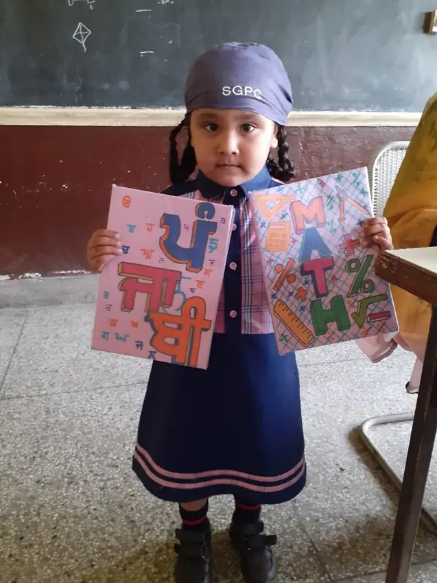 A young pupil displaying colourful artwork
